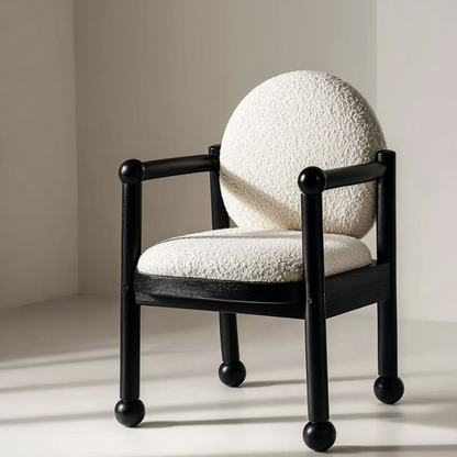 Chair with a textured white cushion and black frame on a neutral background