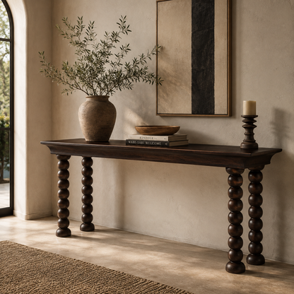 Monolith Console Table in dark walnut oak styled in a modern luxury entryway with ceramic vase, decorative books, artwork, and candle holder.